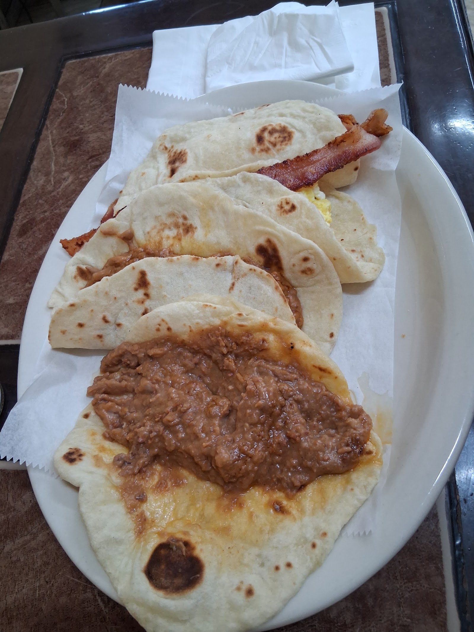 Breakfast tacos with bacon and egg on flour tortillas